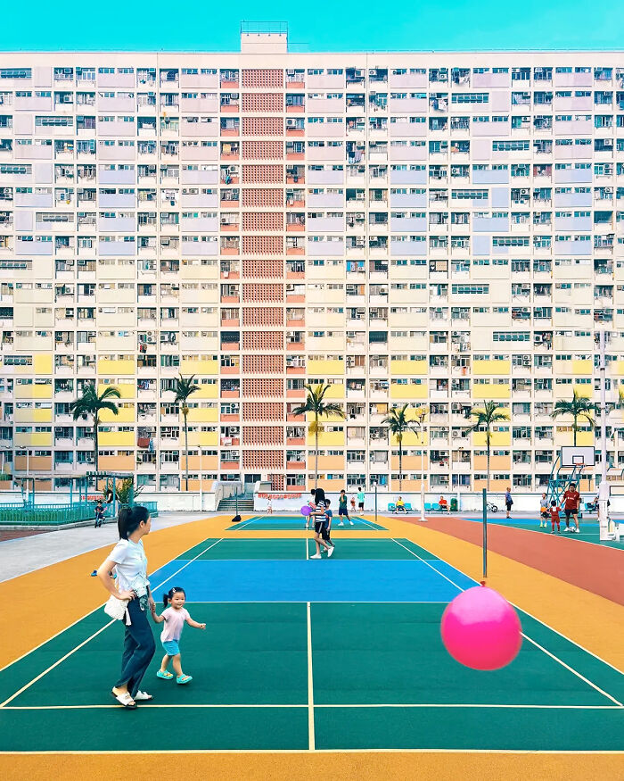 Remarkable color photo capturing the world: a vibrant multi-colored basketball court in front of a tall residential building.