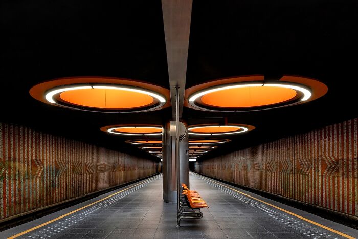Remarkable color photo of an empty, well-lit subway station with unique orange circular lights, capturing the world.