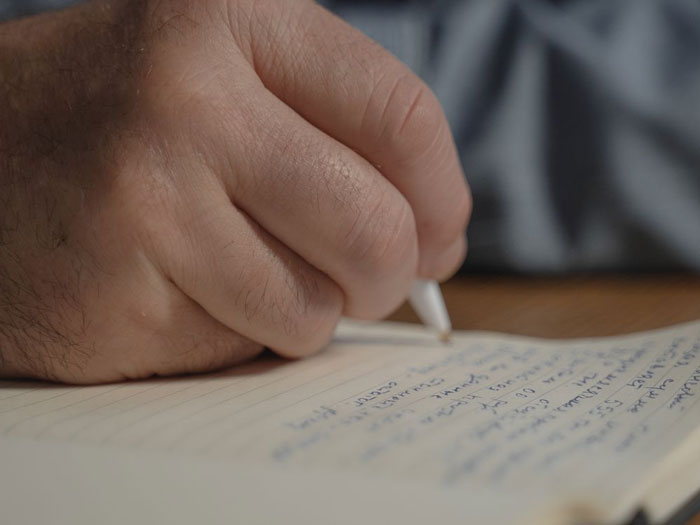 A hand writing with a pen, leading to MIL calling cops to evict DIL but accidentally evicts herself.