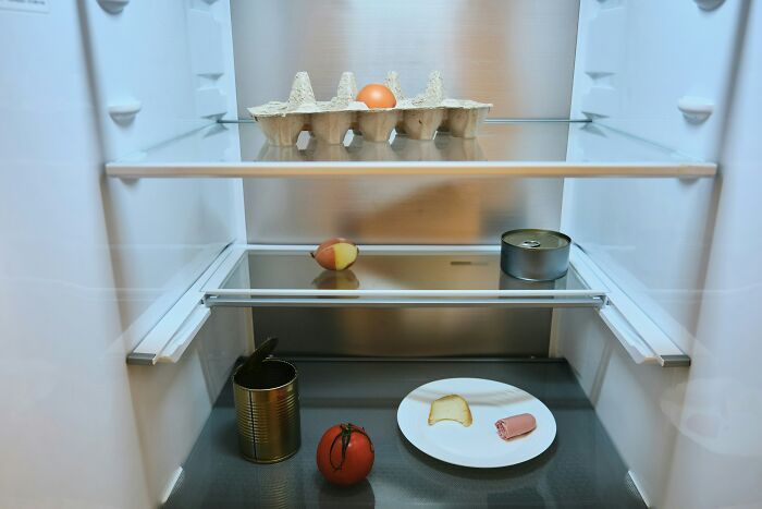 A nearly empty refrigerator with minimal food, making guests feel like they’d never return to this home.