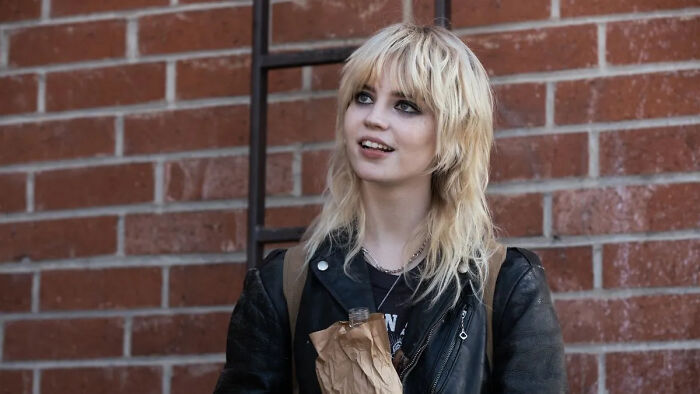 A woman with a flawless look against a brick wall, reflecting on Hollywood's unrealistic beauty standards. A woman with a flawless look against a brick wall, reflecting on Hollywood's unrealistic beauty standards.
