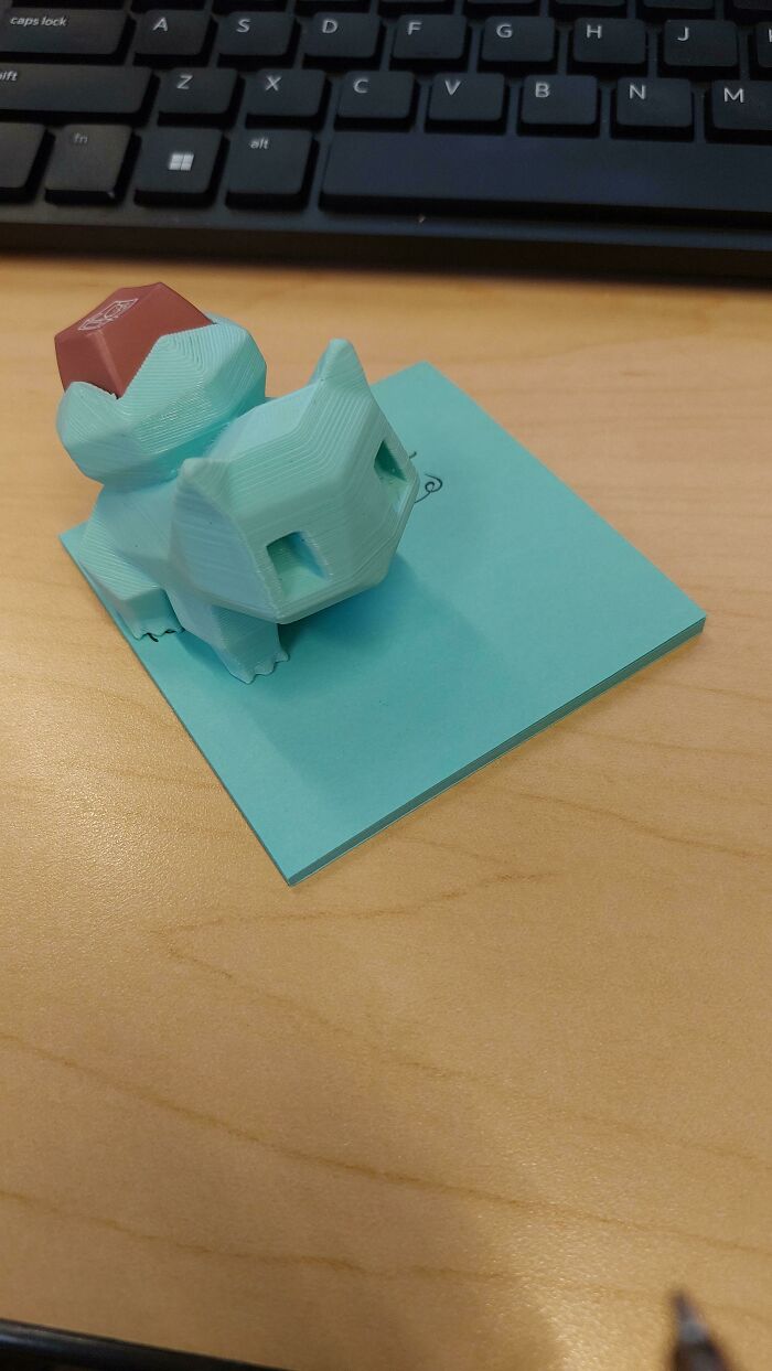 3D printed Bulbasaur figurine with a keyboard key on its back, an incredibly satisfying paint match on a blue sticky note.
