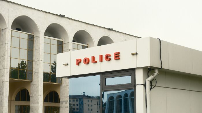 A police building with a red POLICE sign, symbolizing investigations into mysteries.