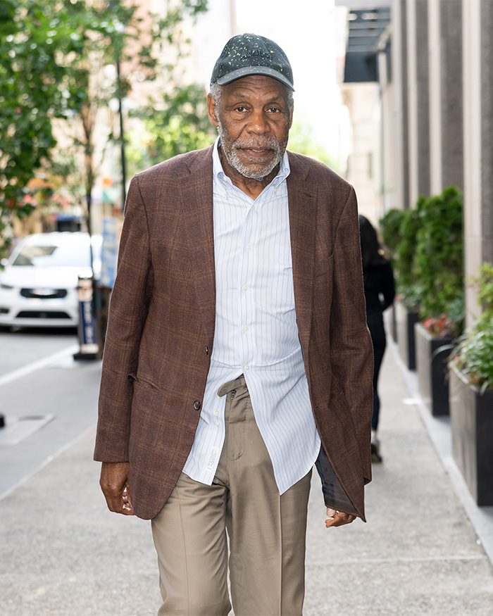 Danny Glover walking on a city street, wearing a cap, with a doctor sharing warning symptoms. Danny Glover walking on a city street, wearing a cap, with a doctor sharing warning symptoms.