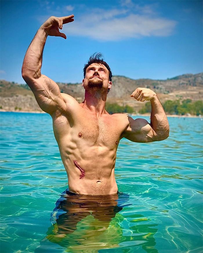 A lookmaxxer in water flexing, showing his extreme transformation and muscular body with a visible scar. A lookmaxxer in water flexing, showing his extreme transformation and muscular body with a visible scar.
