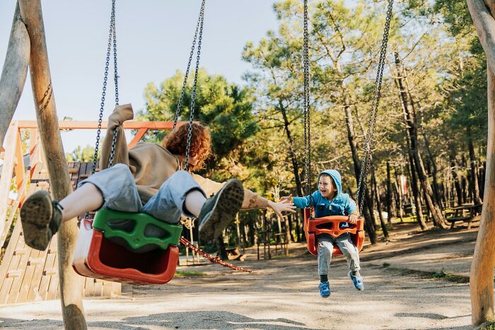 Two children on swings, finding fun and joy in an unconventional way, a metaphor for strange jobs.