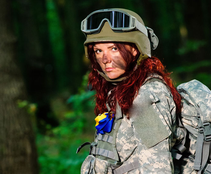 A woman in airsoft gear, with a serious expression, after being booted for ignoring the dress code. A woman in airsoft gear, with a serious expression, after being booted for ignoring the dress code.