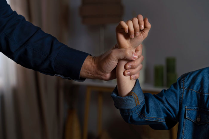Husband grabbing a child's arm, showcasing his violent reaction to allergic SIL eating peanuts. Husband grabbing a child's arm, showcasing his violent reaction to allergic SIL eating peanuts.