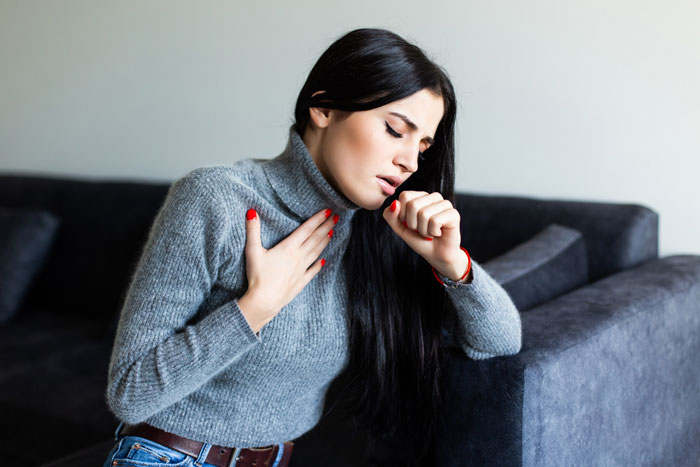 A woman suffering an allergic reaction after accidentally being served peanuts, showing distress and coughing. A woman suffering an allergic reaction after accidentally being served peanuts, showing distress and coughing.