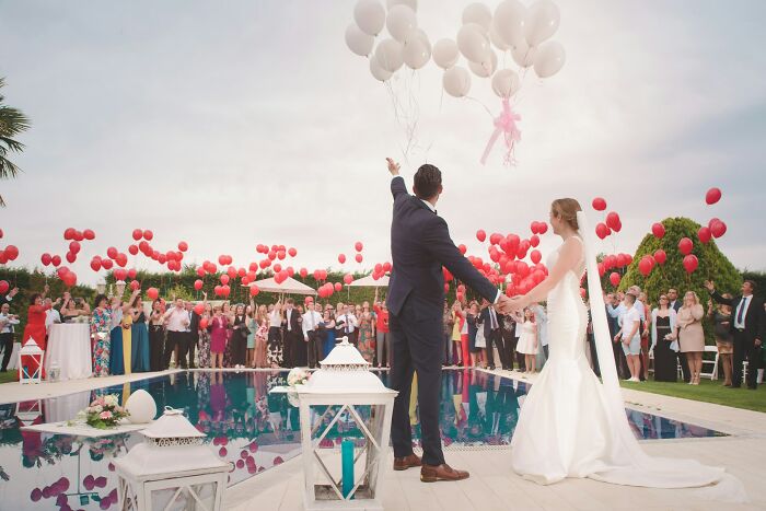 A bride and groom releasing balloons at a wedding, representing the start of a marriage that could later lead to divorce.
