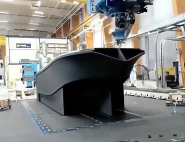 A large industrial machine uses 3D printing to create a boat hull, demonstrating amazing 3D printing creations.