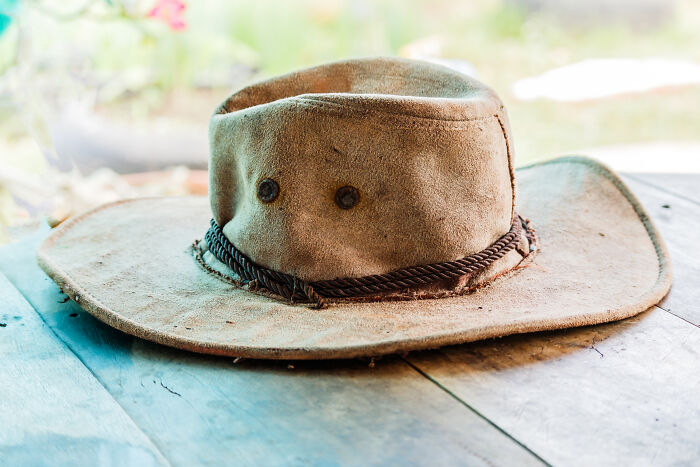 A worn, dusty hat on a wooden table, symbolizing the resilience of World War II veterans' extraordinary stories.