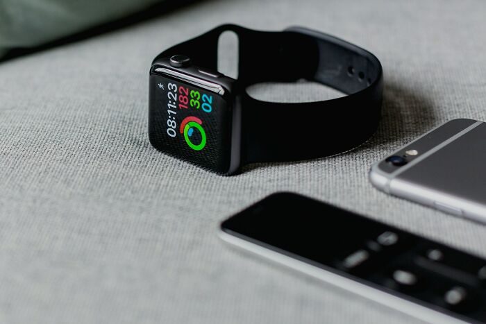 A smartwatch and smartphone on a surface, representing how intuition and technology can provide accurate insights.