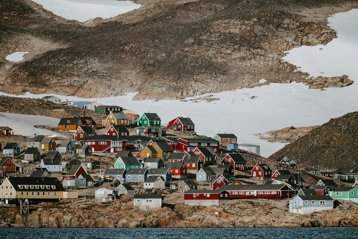 A colorful village nestled amongst snowy mountains by the sea. Discover intriguing history facts.