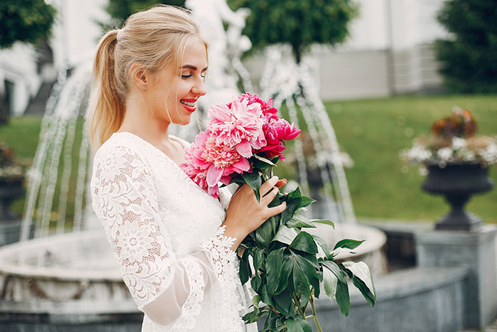 A happy woman, the bride-to-be, in a white wedding gown, holding a bouquet of pink flowers, banning her aunt. A happy woman, the bride-to-be, in a white wedding gown, holding a bouquet of pink flowers, banning her aunt.