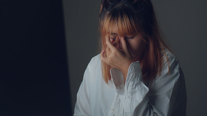 A woman, heartbroken after her aunt changed her grandpa's will, covers her face in distress. A woman, heartbroken after her aunt changed her grandpa's will, covers her face in distress.