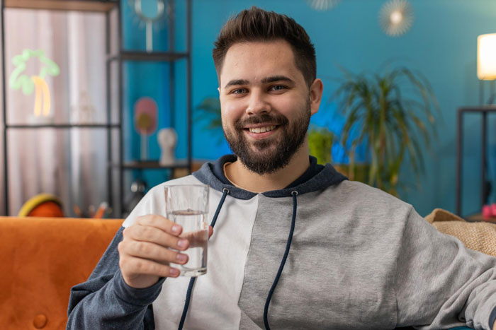 A smiling man with a beard holding a glass of water, illustrating the guy who uses autism as an excuse to tear into sis. A smiling man with a beard holding a glass of water, illustrating the guy who uses autism as an excuse to tear into sis.