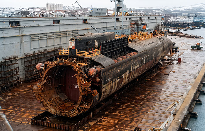 The 9/11 remains of a submarine are seen in a dry dock, with its internal structure exposed.