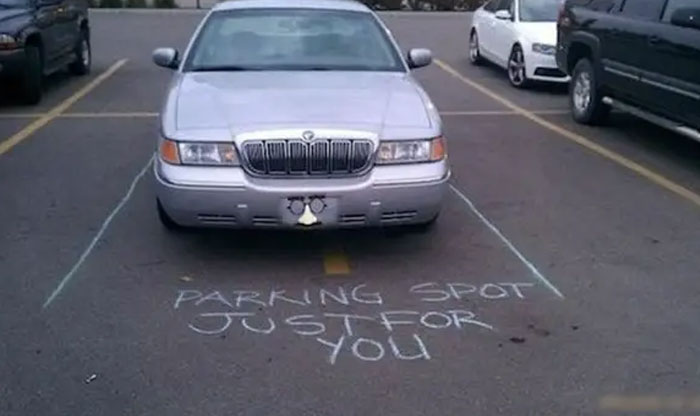 A car with chalk lines drawn around it, making fun of its outrageous parking.
