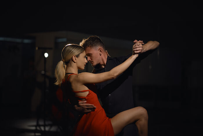 Bartenders overhear: a couple dancing passionately in a dark, intimate setting, sharing intense conversations.