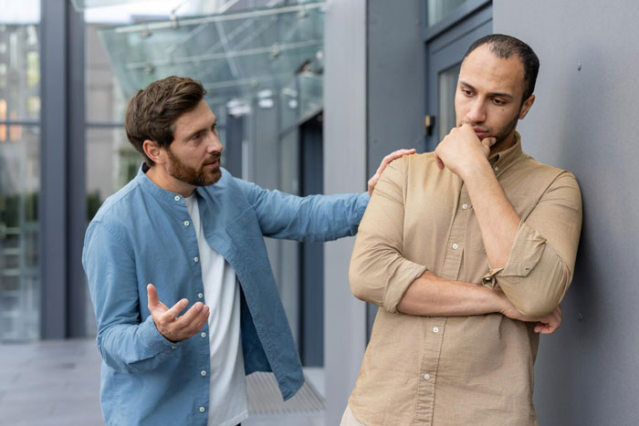 Friend rebuilds life, then allegedly copies business: Two men outside, one comforting the other, illustrating trust and betrayal. Friend rebuilds life, then allegedly copies business: Two men outside, one comforting the other, illustrating trust and betrayal.