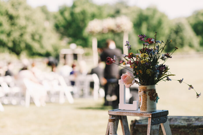 An outdoor wedding setting with a flower arrangement and a LOVE sign, depicting a wedding people regret.