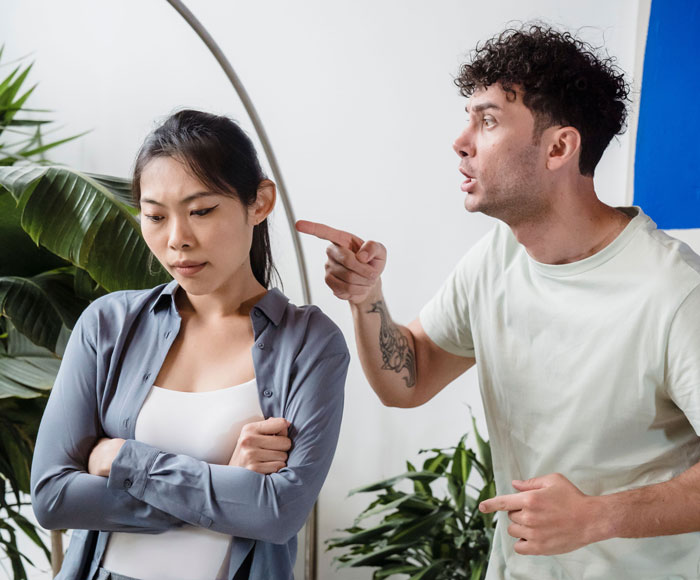 A man angrily points at a woman, discussing chopstick etiquette in a relationship disagreement. A man angrily points at a woman, discussing chopstick etiquette in a relationship disagreement.