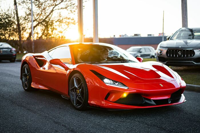 A vibrant red sports car driving on a sunny day, representing a fascinating thing you probably didnt know about the world.