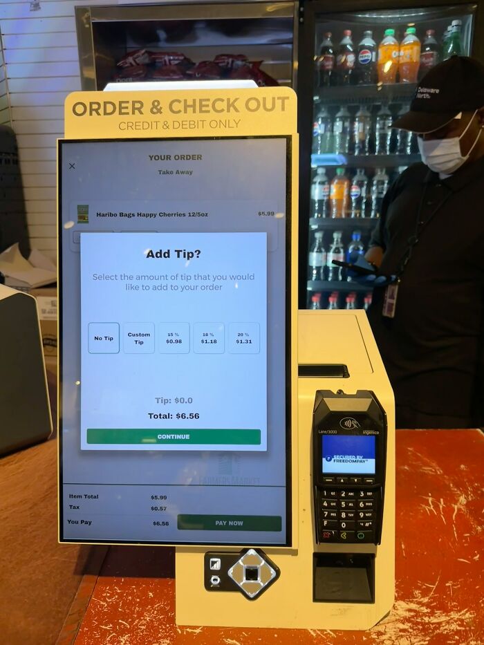 A self-checkout screen prompting an Add Tip option, showcasing American habits.