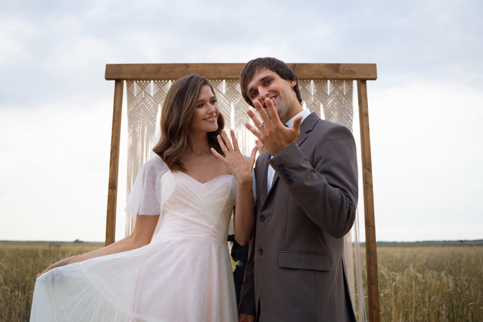 A happy bride and groom showing off their rings, related to issues with bridesmaid dresses. A happy bride and groom showing off their rings, related to issues with bridesmaid dresses.