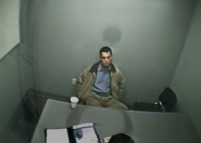 Scott Peterson in an interrogation room, sitting at a table with a cup, during the homicide investigation. Scott Peterson in an interrogation room, sitting at a table with a cup, during the homicide investigation.