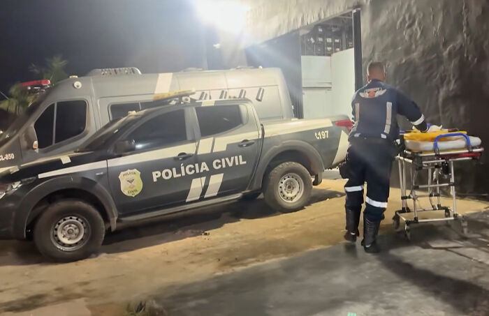 Police and medical personnel with an ambulance and stretcher at night, responding to a revenge plot incident.