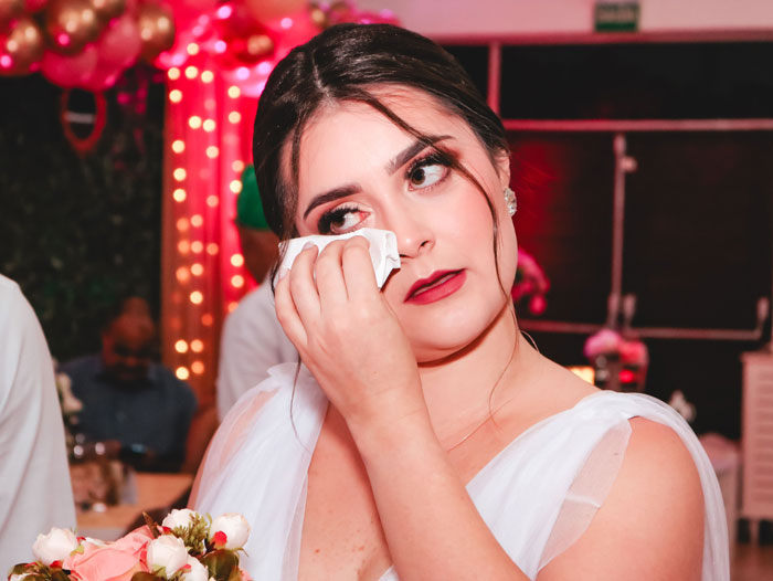 A crying bride wiping her eyes on her wedding day, reflecting the pain of being ghosted by her influencer bestie. A crying bride wiping her eyes on her wedding day, reflecting the pain of being ghosted by her influencer bestie.