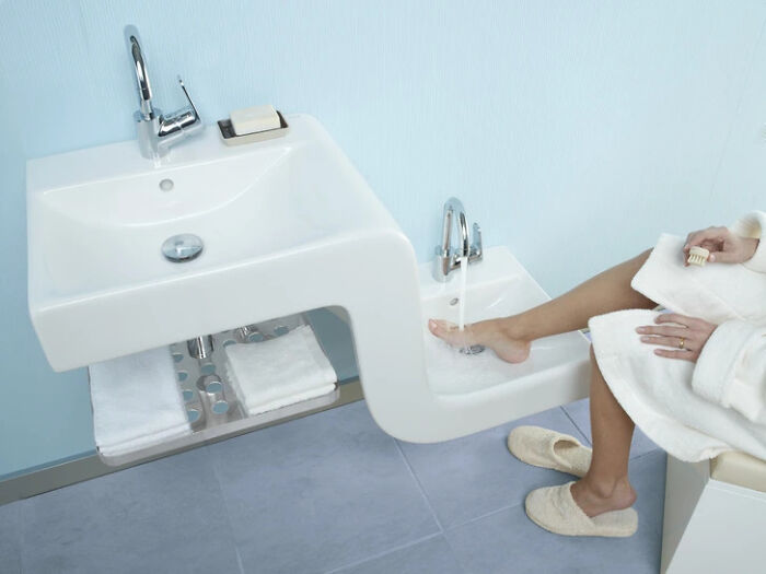 A woman soaking her foot in a custom sink with two basins, a brilliant design transformation of an ordinary thing.