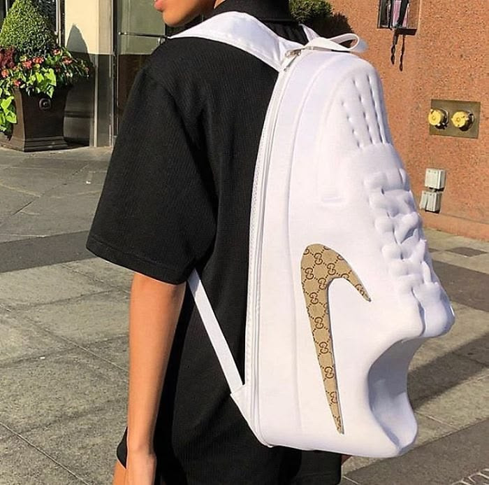A person wears a backpack designed like a giant white sneaker with a Gucci logo, brilliantly transforming ordinary things.