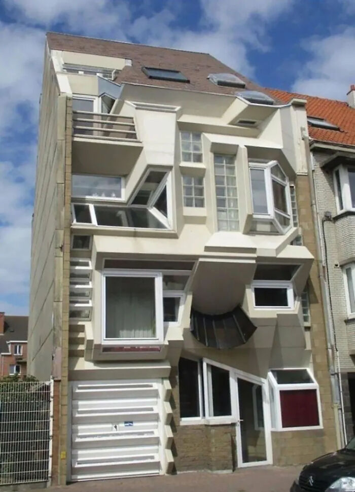 An oddly designed house with misaligned windows, a prime example of construction fails.