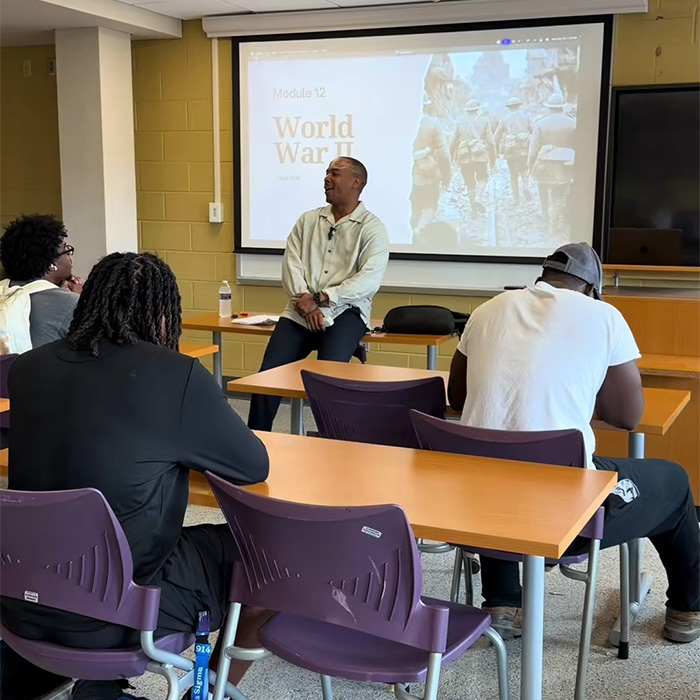 A college professor lecturing students, discussing AI use and detection during a final exam.