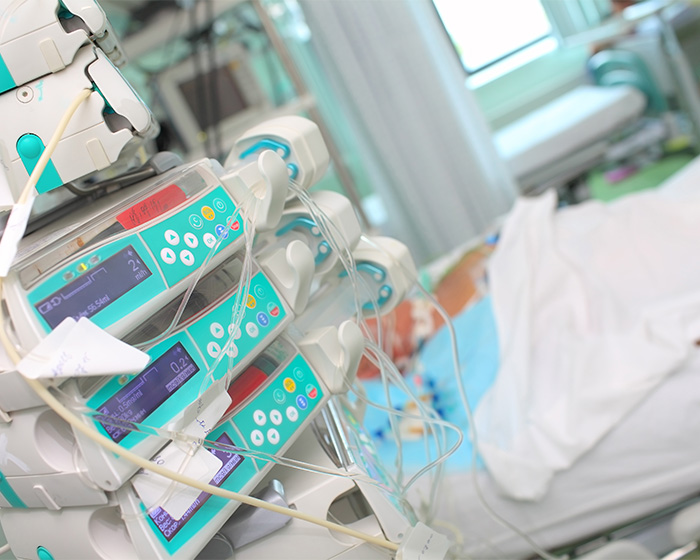 Medical equipment hooked up to a patient in a hospital bed, symbolizing the medical emergency and doctor's alert. Medical equipment hooked up to a patient in a hospital bed, symbolizing the medical emergency and doctor's alert.