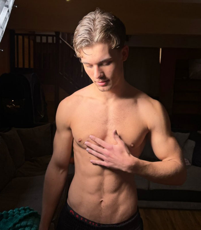 Controversial father-son adult content creators, son posing shirtless with hand on chest. Controversial father-son adult content creators, son posing shirtless with hand on chest.