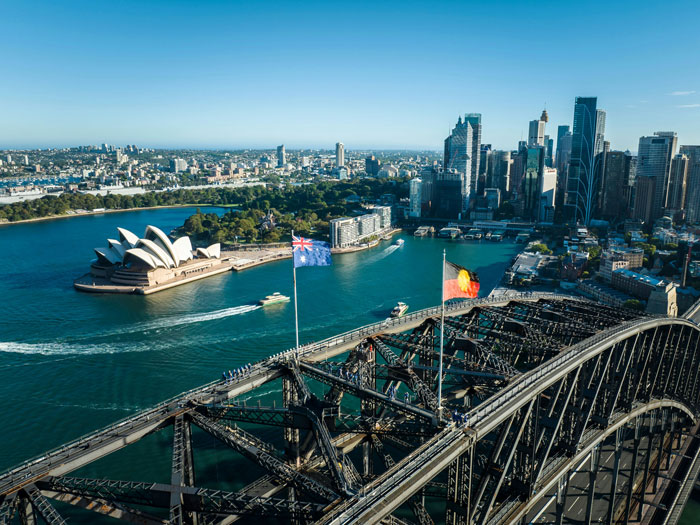Sydney Opera House and Harbour Bridge with flags flying, symbolizing countries that made it out alive from nuclear war.