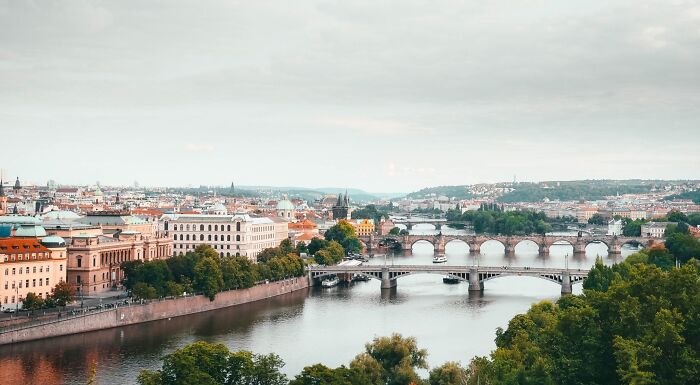 A panoramic view of Europe, featuring multiple bridges spanning a river, with historical buildings lining the banks under a cloudy sky. A panoramic view of Europe, featuring multiple bridges spanning a river, with historical buildings lining the banks under a cloudy sky.