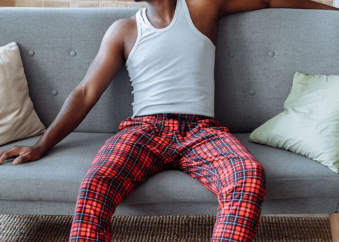 A person in pajamas relaxing on a couch, representing the unexpected comfort in job interview stories.