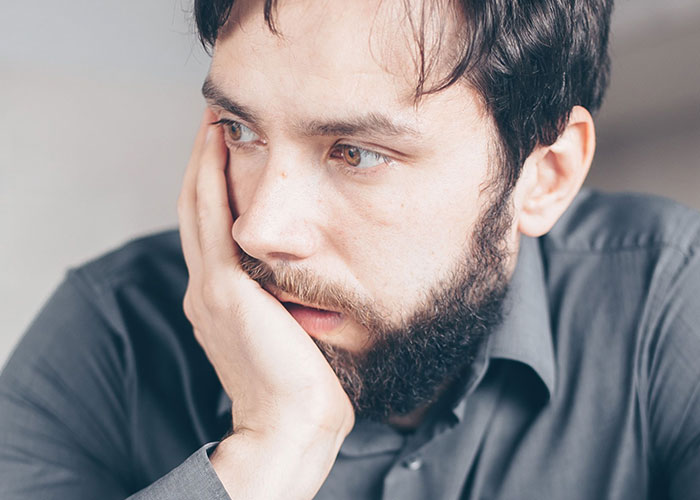 A man with a beard looking worried, illustrating a job interview story that went wrong.