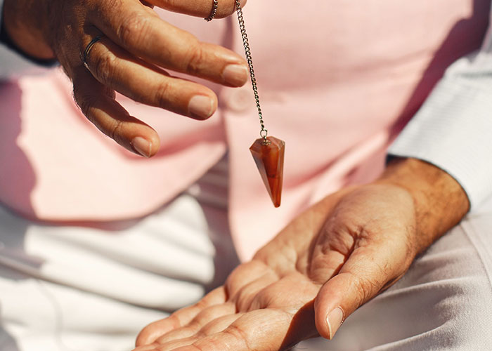 Hands holding a pendulum, reflecting the unpredictable nature of job interview experiences.