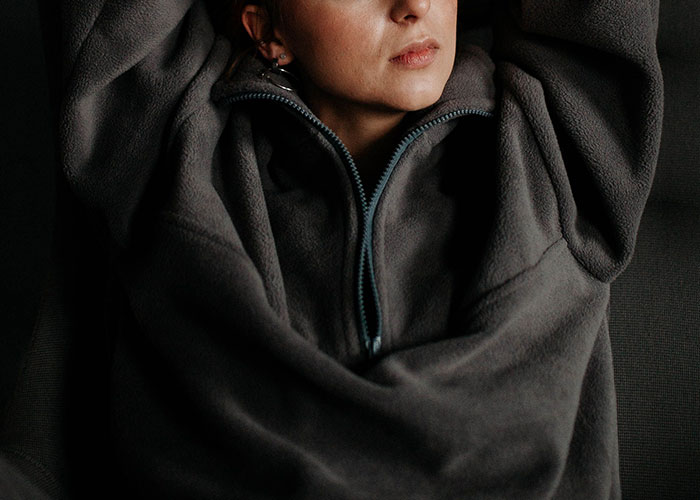 A woman in a cozy fleece, illustrating a relaxed moment amidst job interview stories.