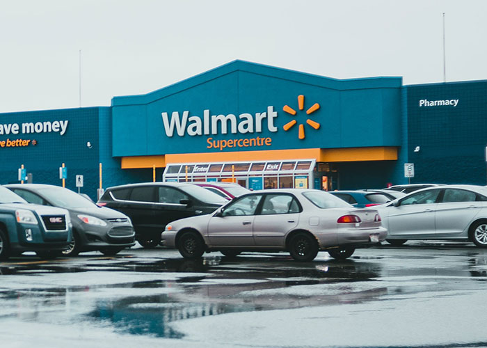 A Walmart Supercentre entrance with parked cars on a wet day, a setting for a job interview story.