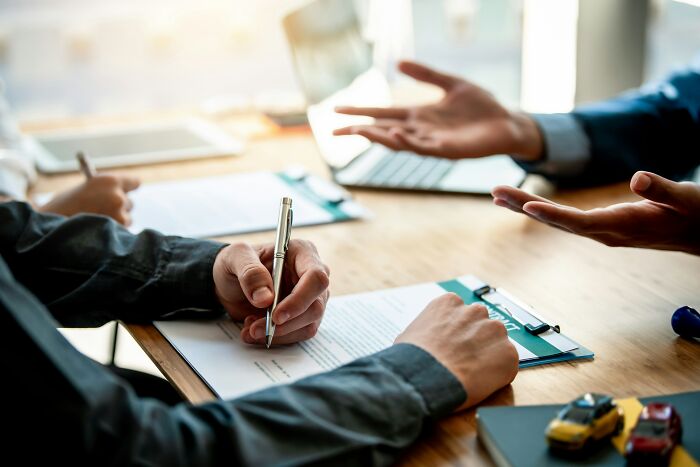 Hands signing a document, symbolizing the legal aspects of a last will, including burial requests.