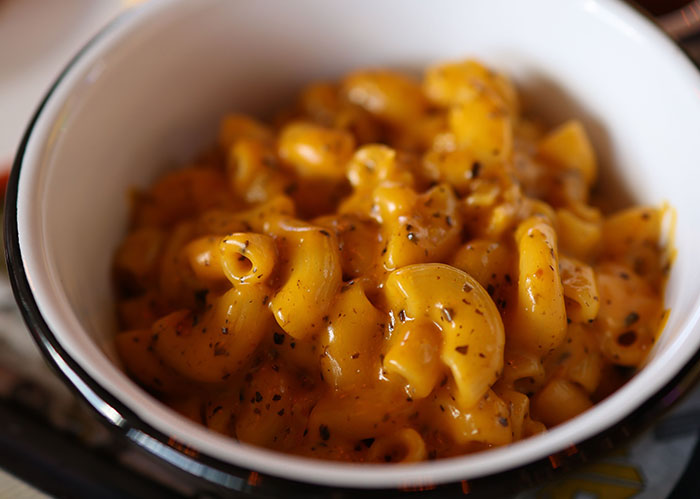 A close-up of macaroni and cheese in a white bowl. Uncover facts about America's favorite foods.