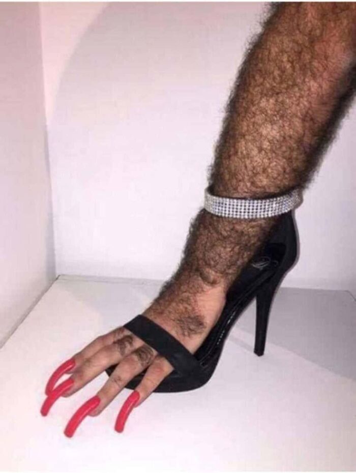 A hairy leg with red fingernails wearing a high heel, one of the creepy and confusing images.