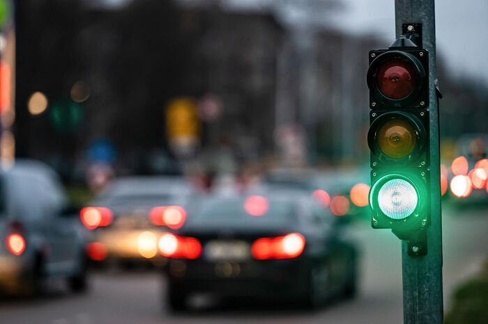 A traffic light shows green, with blurred cars and lights in the background, representing the unexpected nature of childhood experiences.